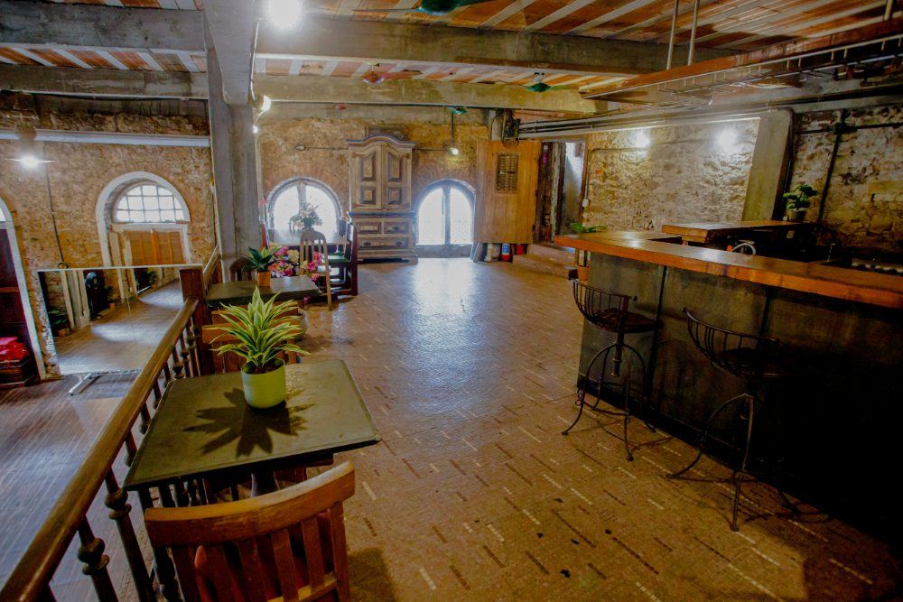 Mezanino, salão superior com paredes de pedra e arcos