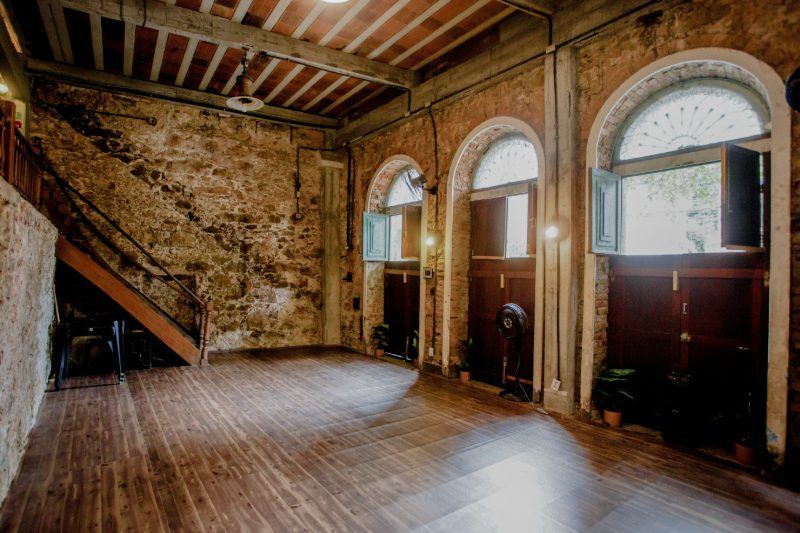 Sala Fluxo com escada de madeira, portas em arco e piso corrido